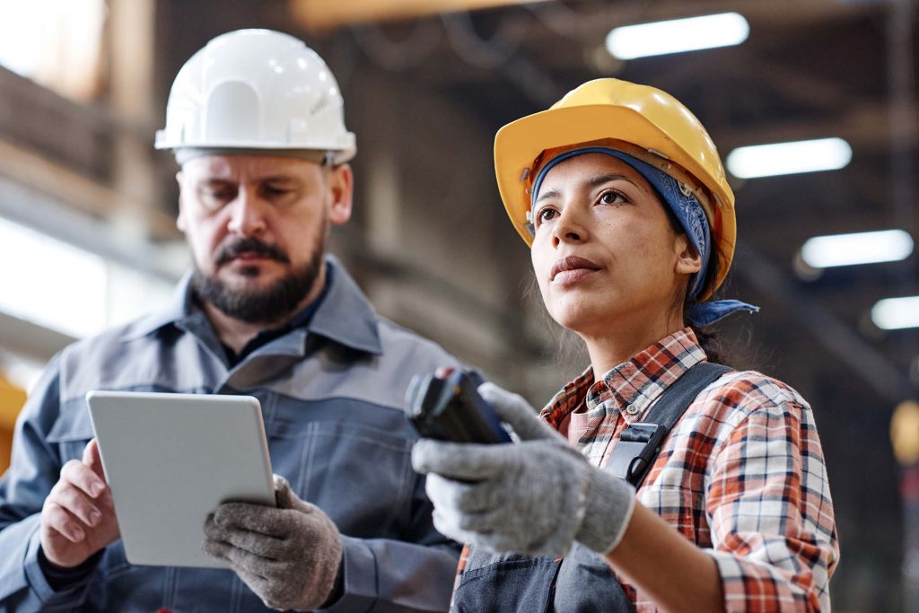 young-hispanic-female-engineer-in-workwear-pressing-button